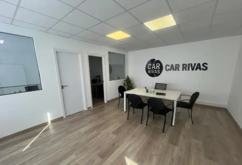 Sala de reuniones o consulta con mesa blanca, sillas negras y logo de CZ Sports en la pared